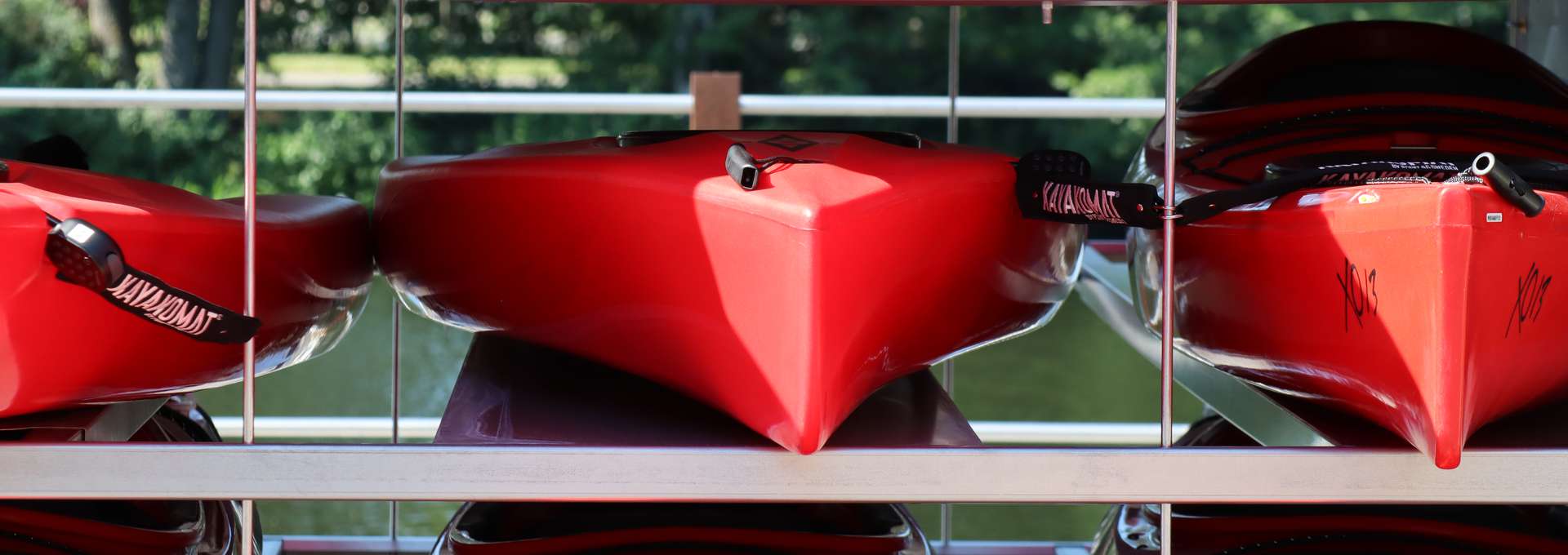 Närbild på röda kayaker med Eskilstunaån i bakgrunden.