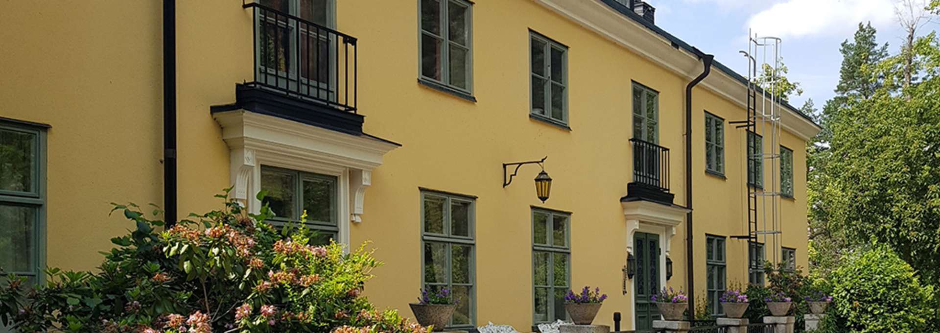 Nyby Herrgård gul stenbyggnad med gröna fönster