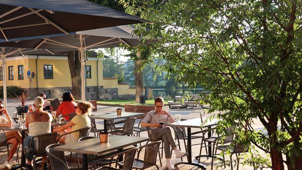 Guests in sunshine at T.Rassen outdoor terrace.