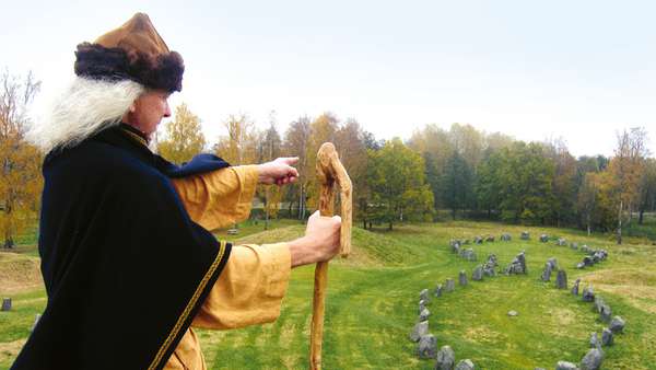 Viking med käpp som pekar mot stenformation