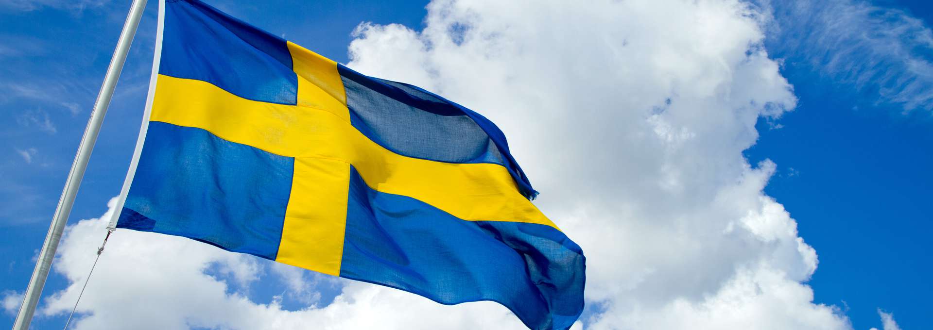 Svenska flaggan mot blå himmel.