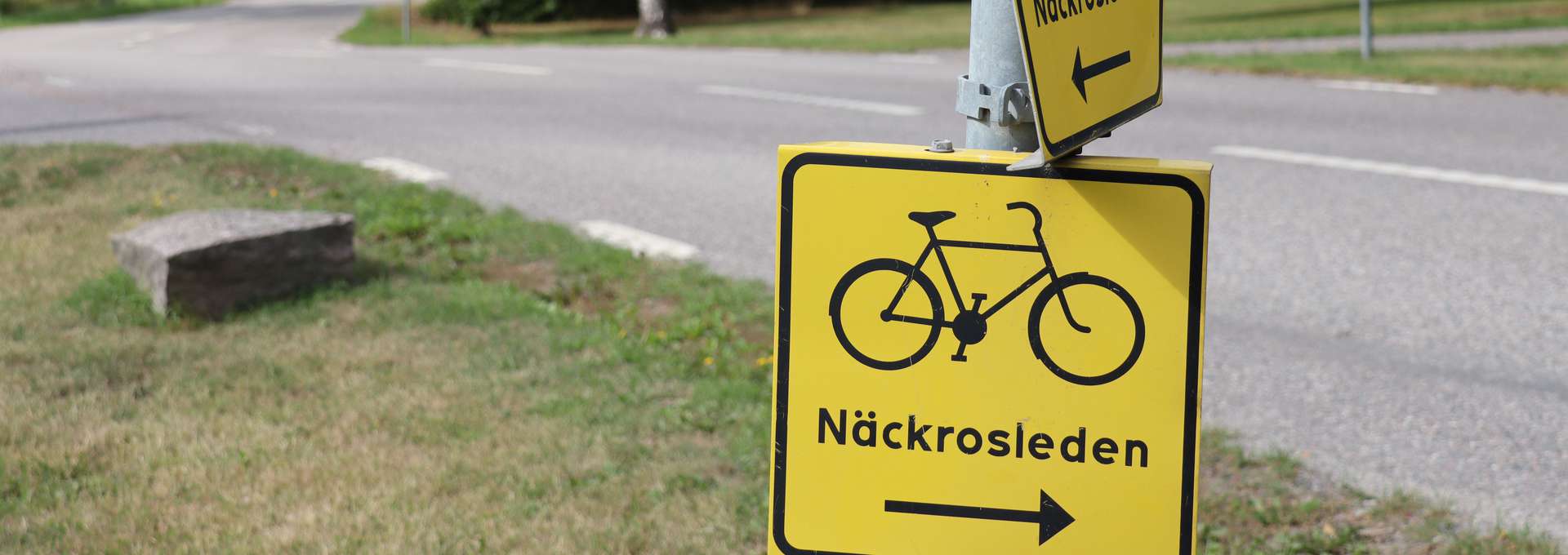 two yellow squared street signs on top of each other, saying Näckrosleden